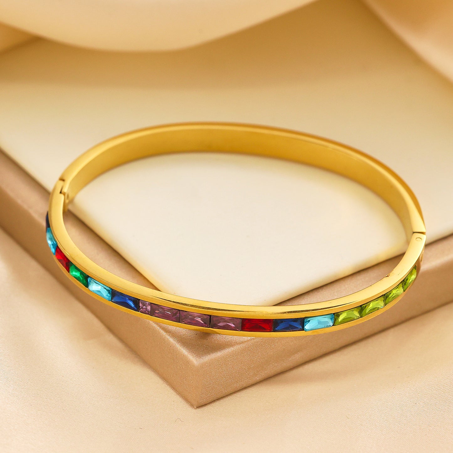 Edelstahlarmband mit 18 Karat Goldbeschichtung und farbigen Edelsteinen