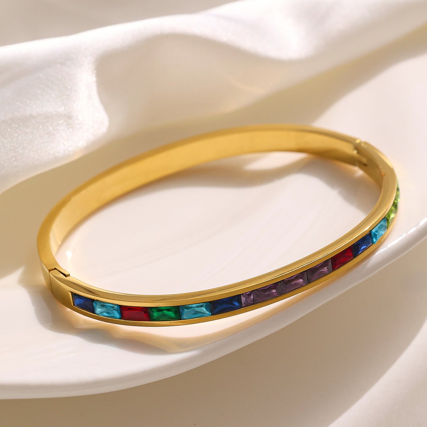 Edelstahlarmband mit 18 Karat Goldbeschichtung und farbigen Edelsteinen